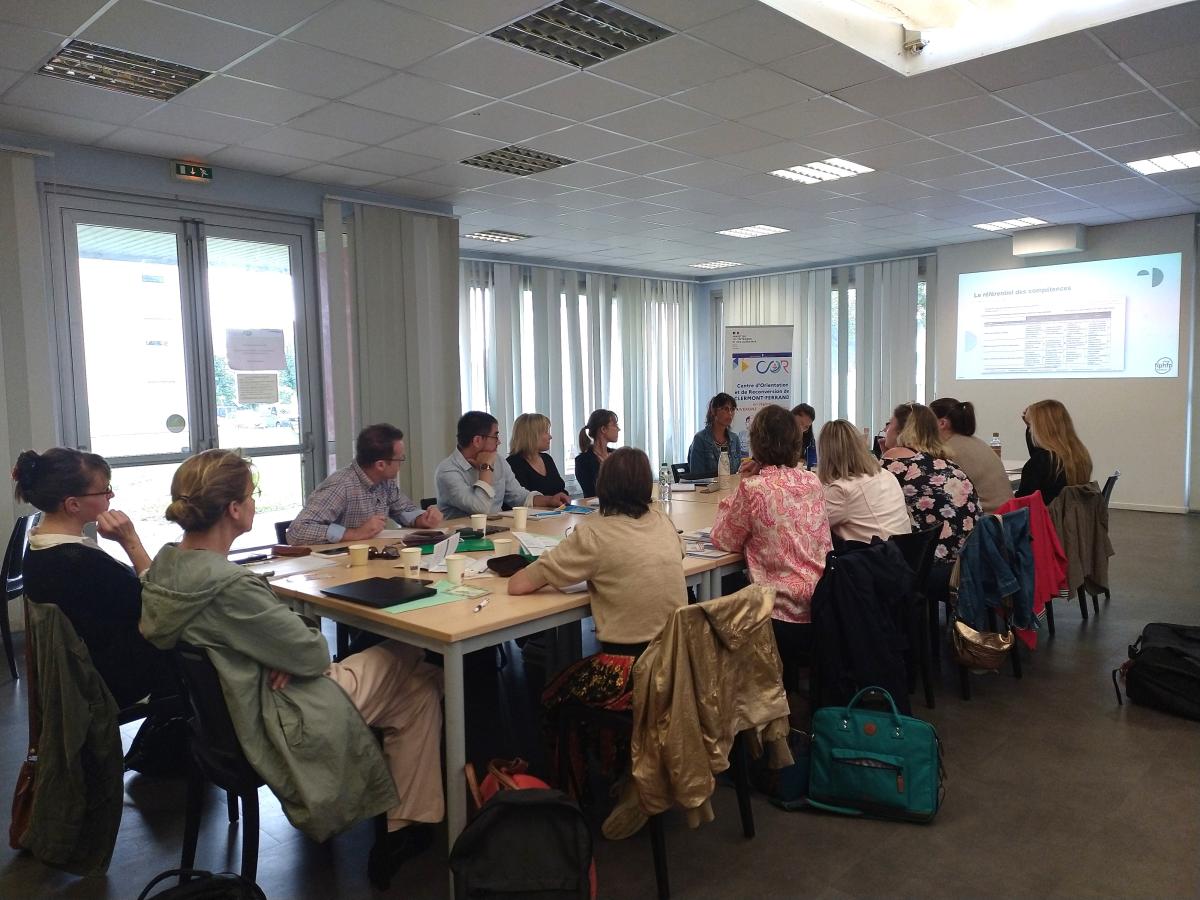 Les membres de la commission mobilité inter fonction publique de Clermont-Ferrand sont assis autour d'une table et regardent un power point projeté sur un mur.