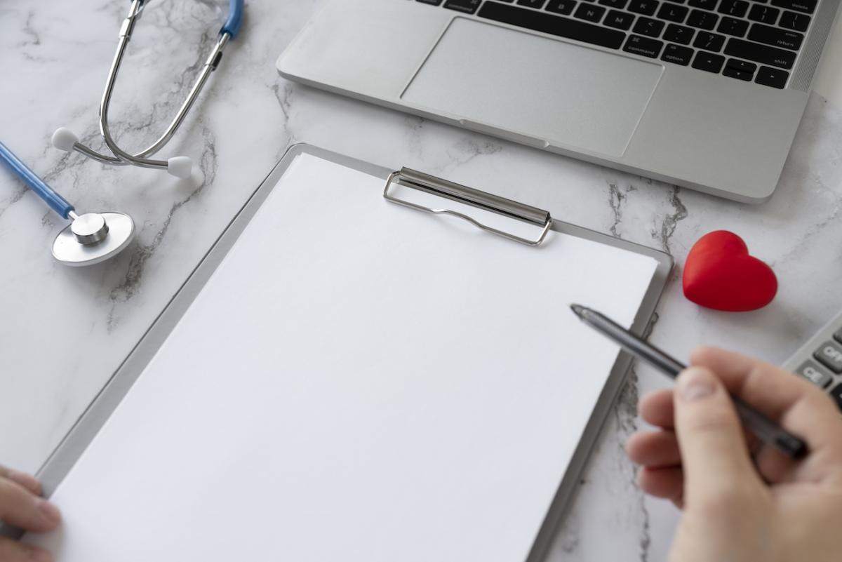 Personne devant une page blanche avec un stylo à la main